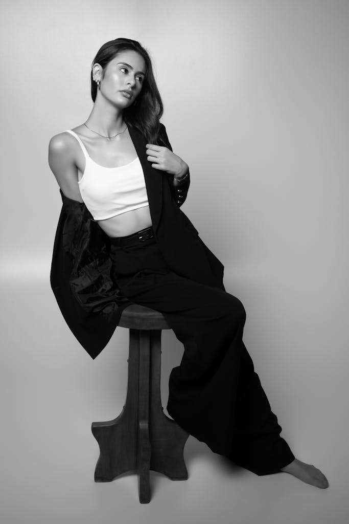 Stylish woman posing gracefully in a black and white studio portrait.